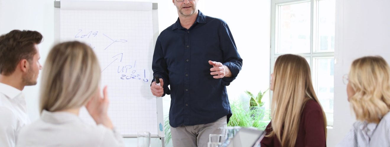 Älterer Mann hält einen Vortrag vor jungen Leuten Joerch - stock.adobe.com